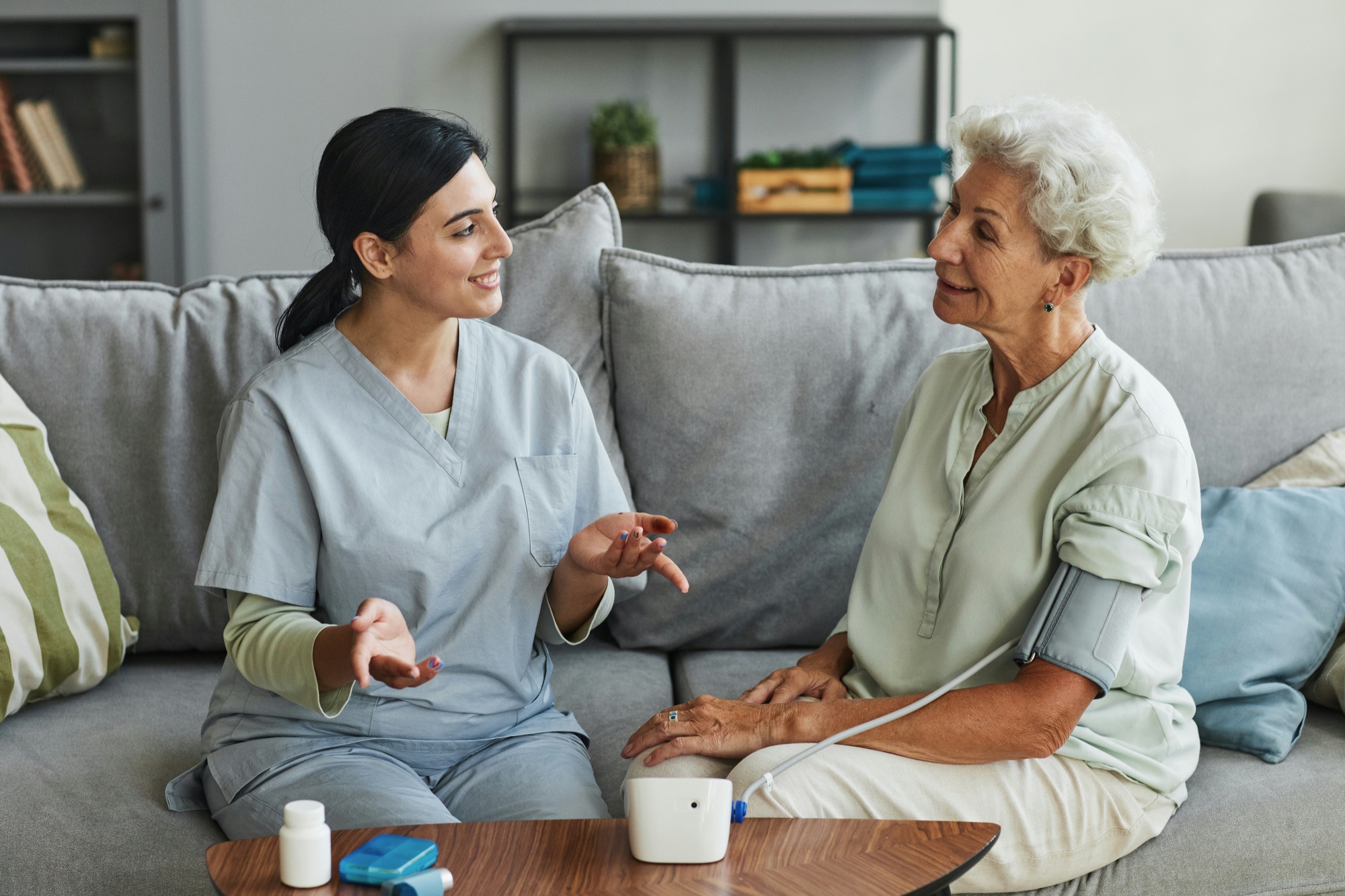 Healthcare worker in conversation with an elderly patient in a home care setting